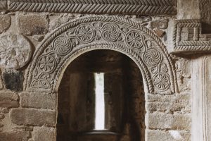 San Miguel de Lillo tras la restauración. Detalle de las roscas decoradas de las puertas laterales.